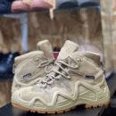 Desert Lowa lowcut hiking boot in tan color on a rocky trail background