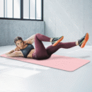 Pink Yoga and Gym Mat rolled on wooden floor
