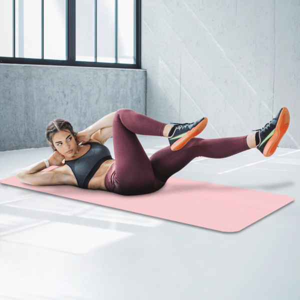 Pink Yoga and Gym Mat rolled on wooden floor